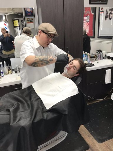 Barber giving a shave to a client in a modern barbershop