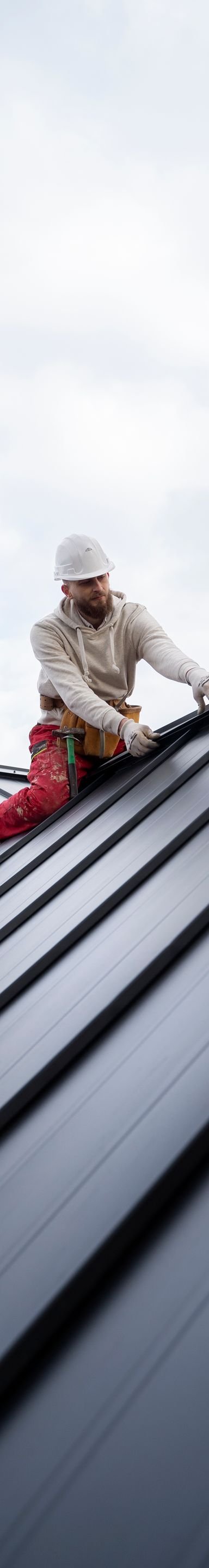 Roofing worker installing metal roof tiles