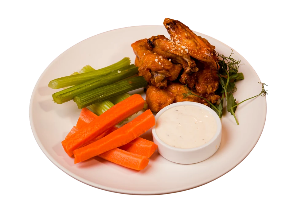 Plate of chicken wings with celery, carrots, and dipping sauce