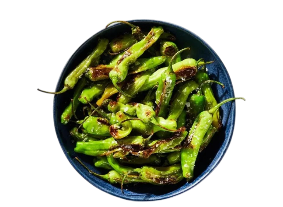A bowl of roasted green peppers on a black background.