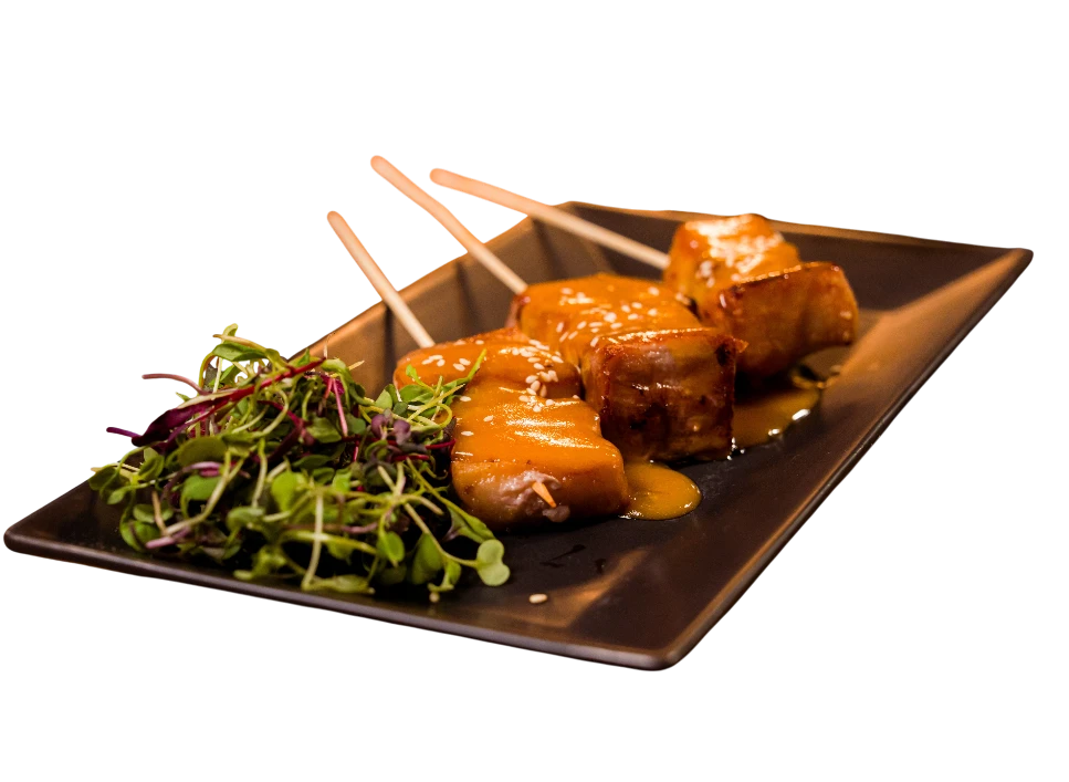 Delicious skewers of meat with sauce and salad on plate