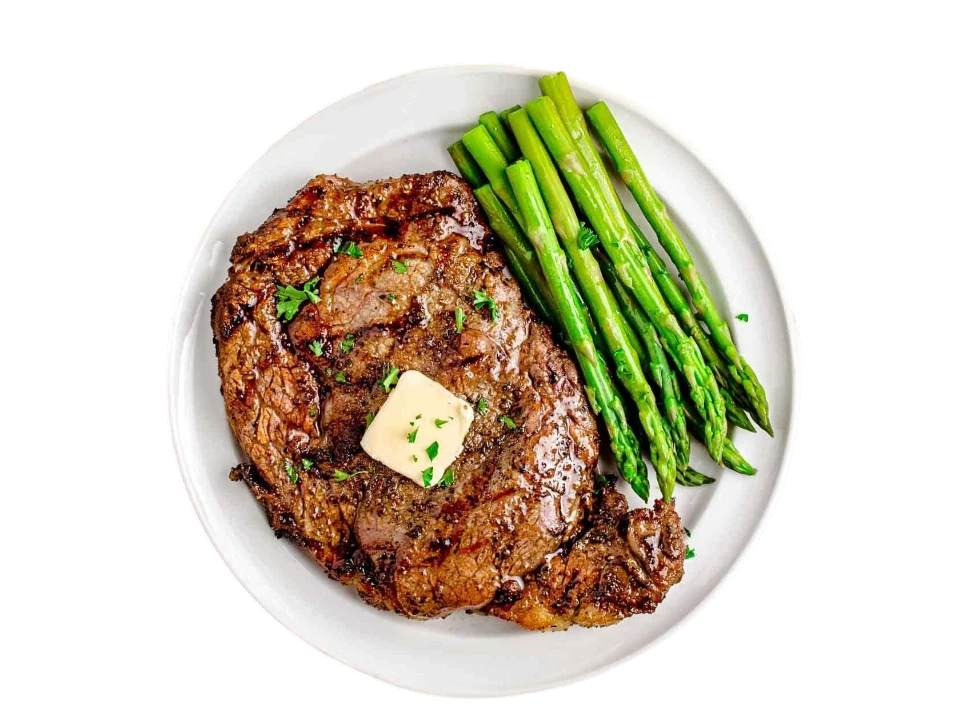 Grilled steak with butter and asparagus on a plate