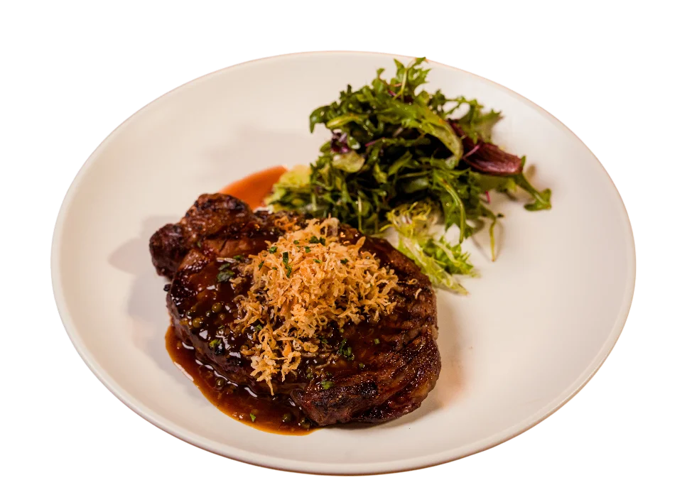 Grilled steak with sauce and green salad on plate
