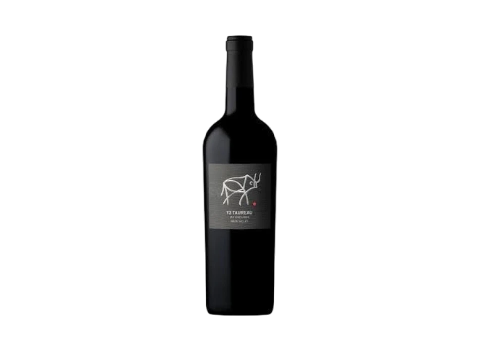A dark bottle of red wine with a minimalist label featuring a white line drawing of a cow, set against a black background.