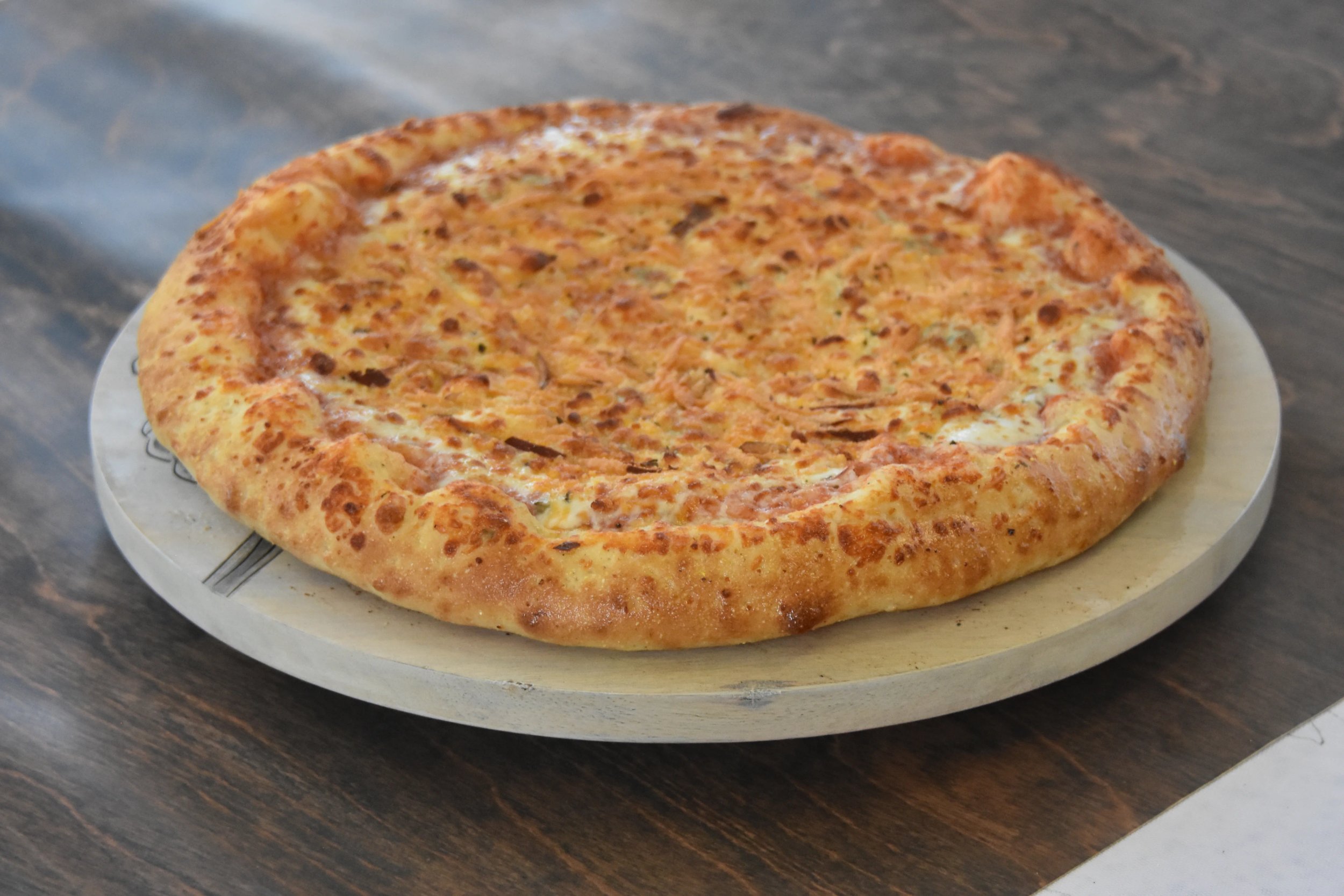 Delicious cheese pizza on a wooden board