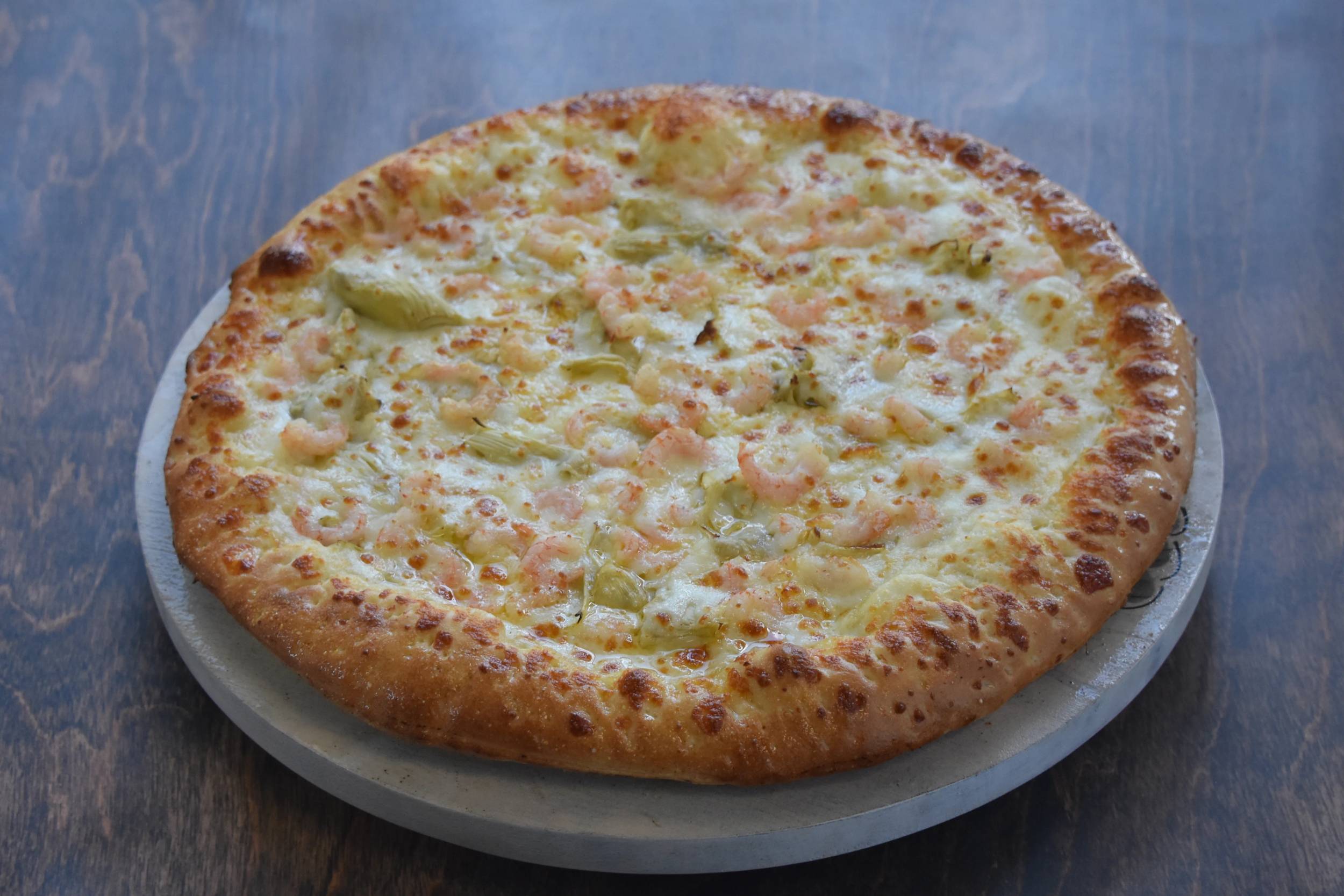 Delicious shrimp pizza on a wooden table