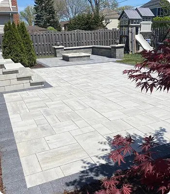 Modern patio with gray stone pavers and landscaping