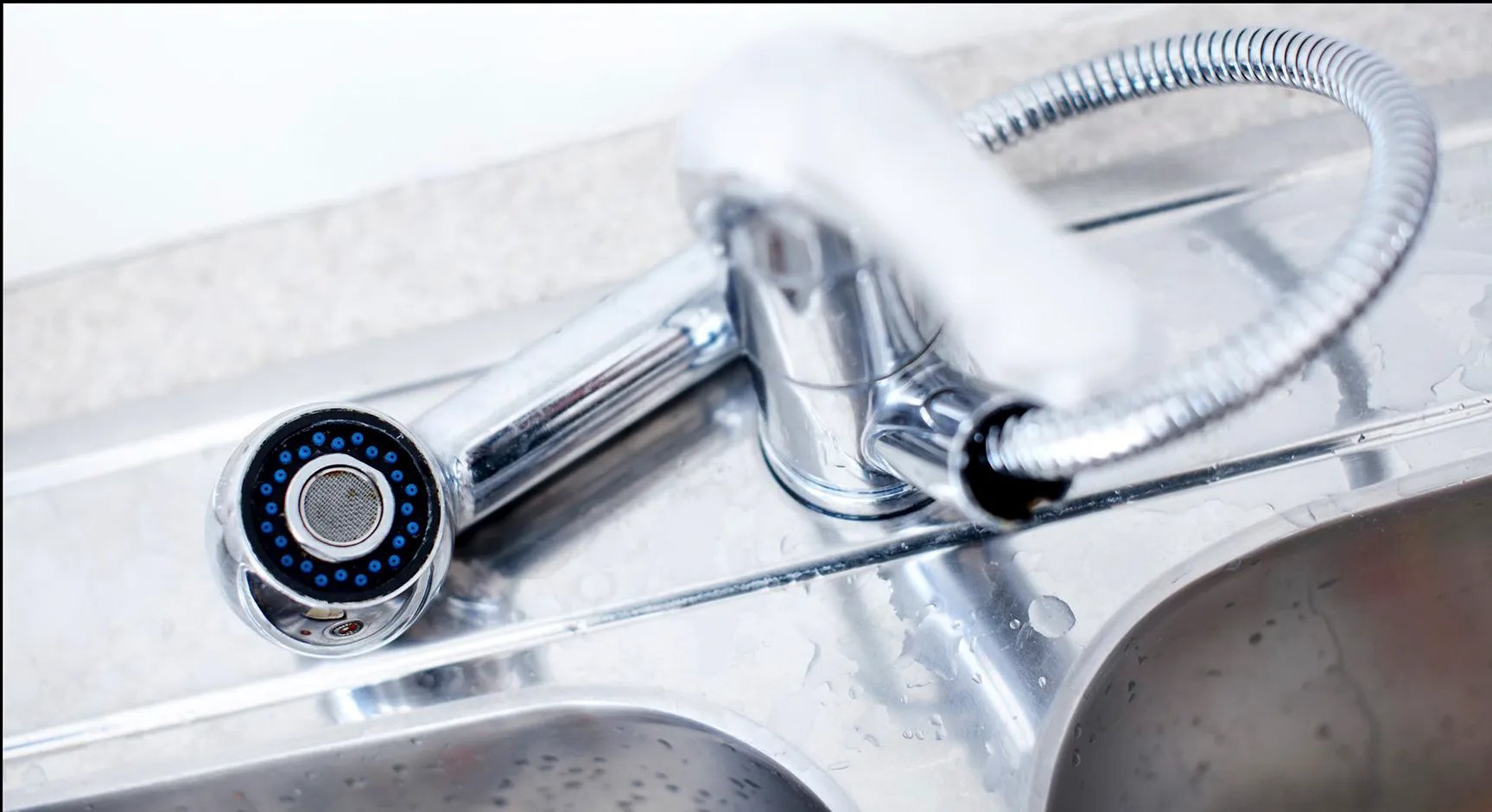 Close-up of a shiny chrome kitchen faucet with sprayer