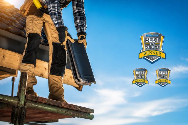 Construction worker installing roofing shingles under clear blue sky.