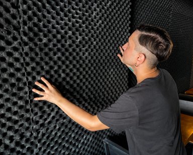 Person touching acoustic foam wall in studio