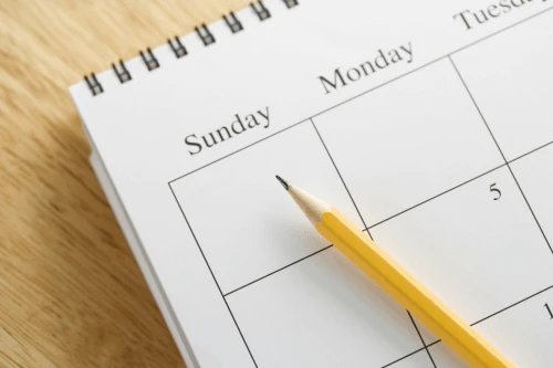Close-up of open calendar with pencil indicating Sunday