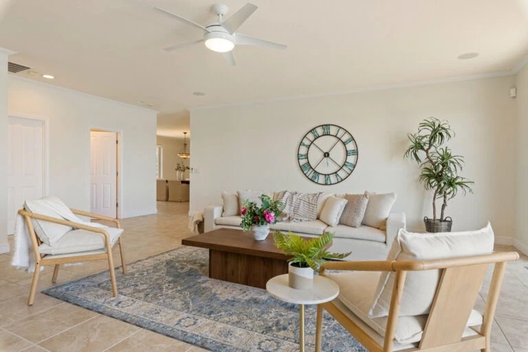 Modern living room with a beige sofa, clock, and plants