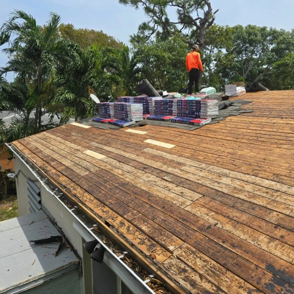 Roofing contractor working on a house roof with materials.