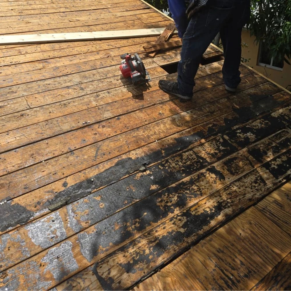 construction worker cutting wooden roof panels