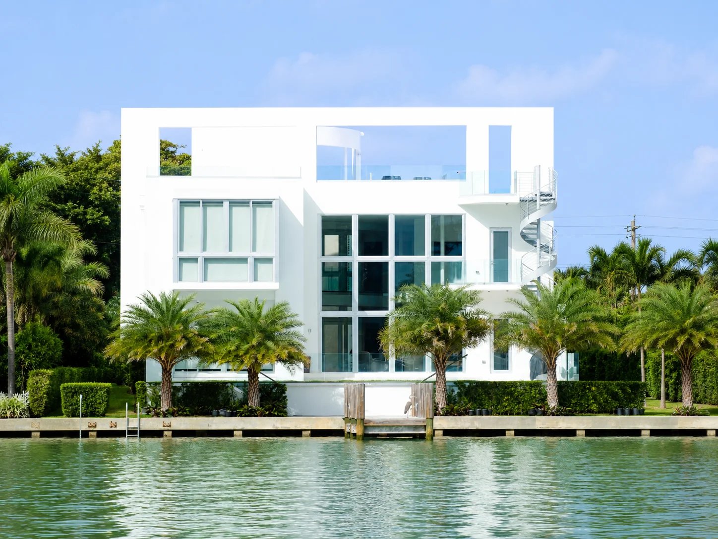 Modern waterfront house with palm trees