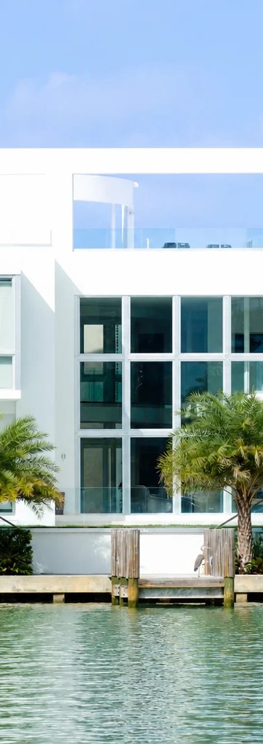Modern waterfront house with palm trees
