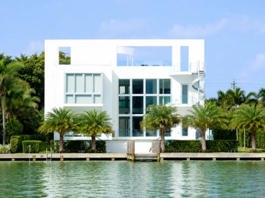 Modern waterfront house with palm trees
