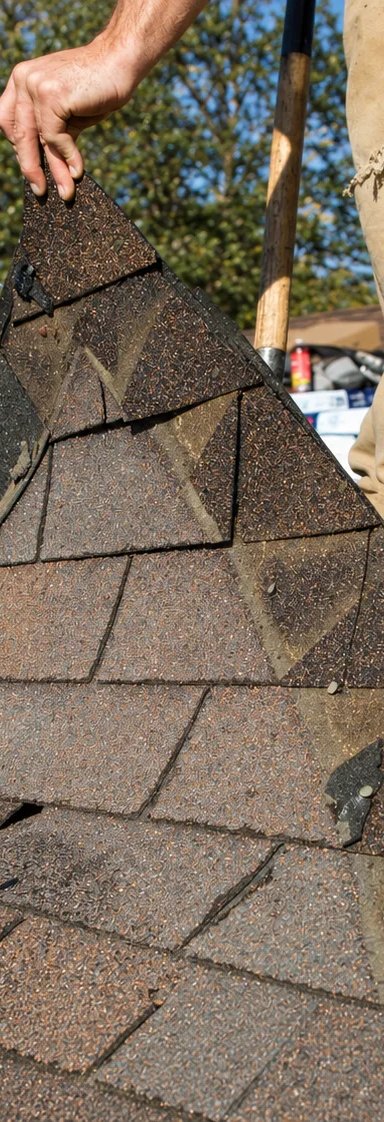 Person replacing shingles on a roof