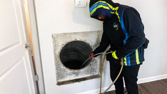 Professional cleaning service employee servicing a vent.