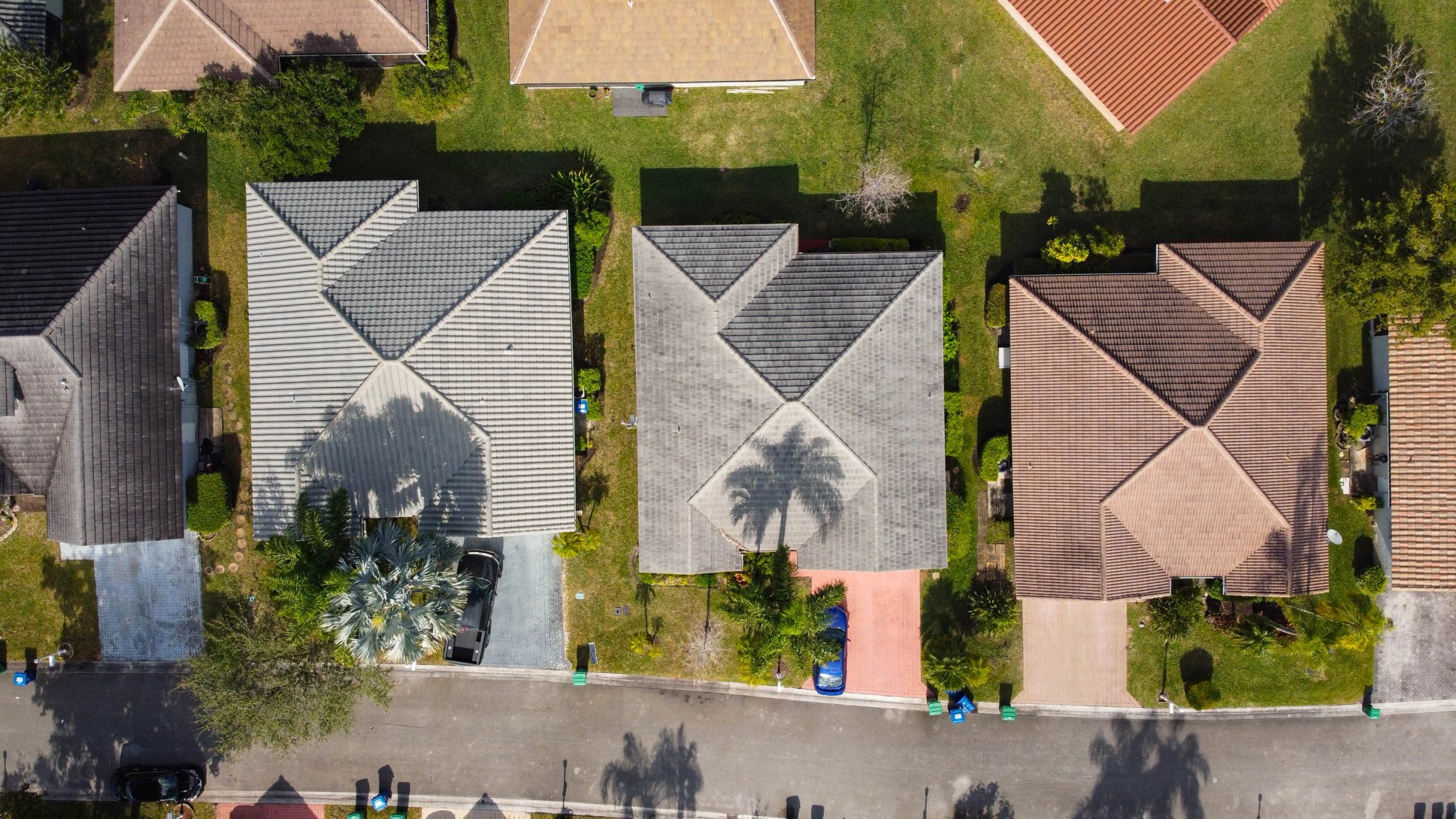 Aerial view of suburban houses with varying roof styles.