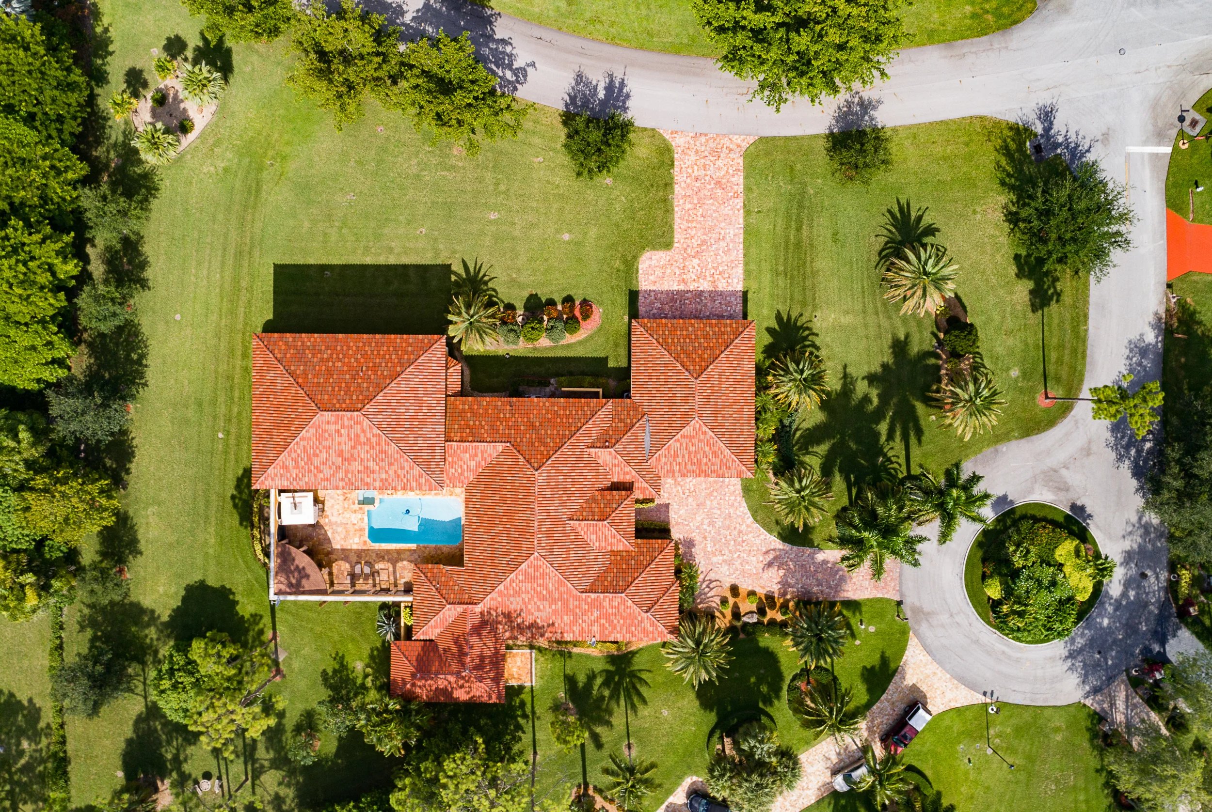 Aerial view of a luxurious villa with palm trees and a pool.