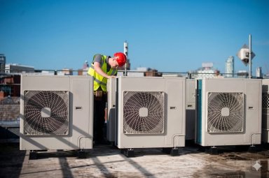 Technician working on rooftop air conditioning units.