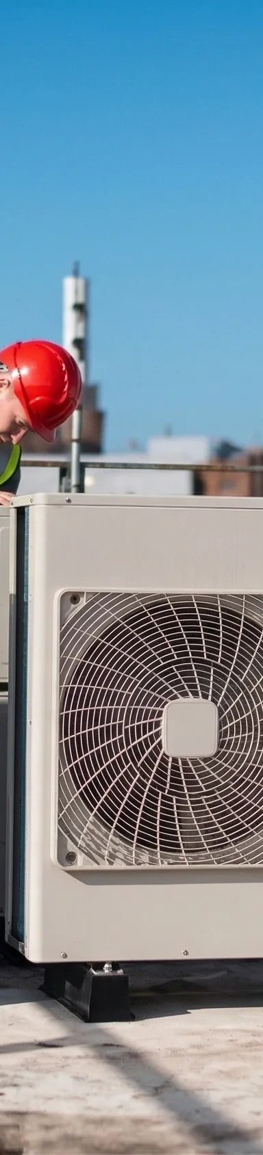 Technician working on rooftop air conditioning units.