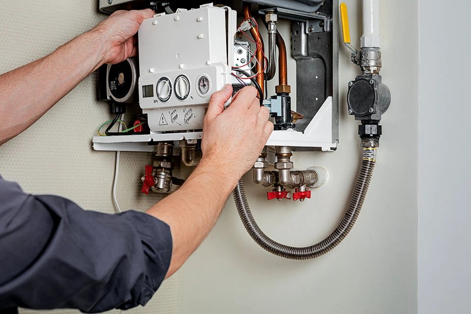 Technician repairing a heating system control unit.