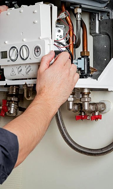 Technician repairing a heating system control unit.