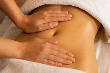 Massage therapy session on a client's abdomen