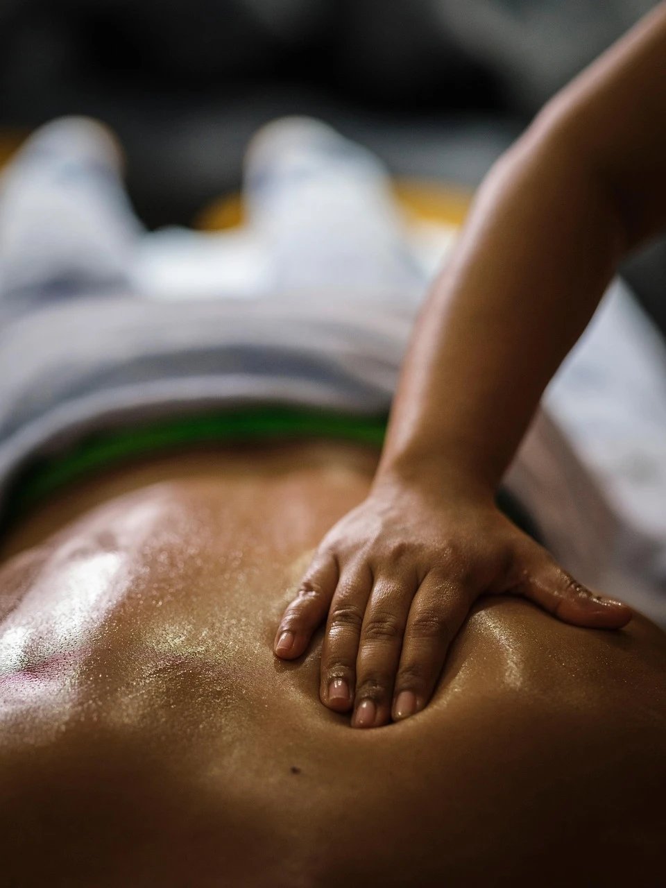 Close-up of a person receiving a massage on their back.