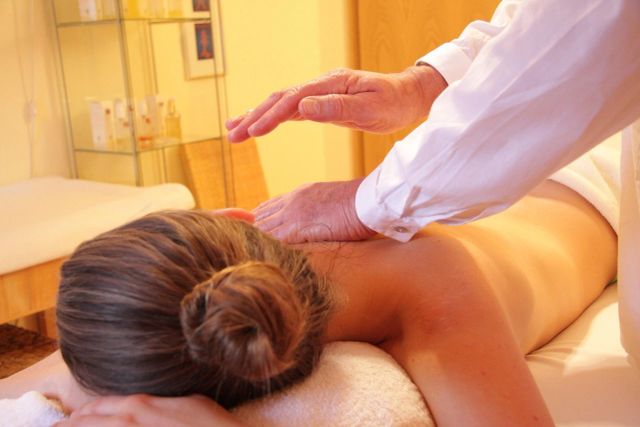 Therapist performing a back massage on a client