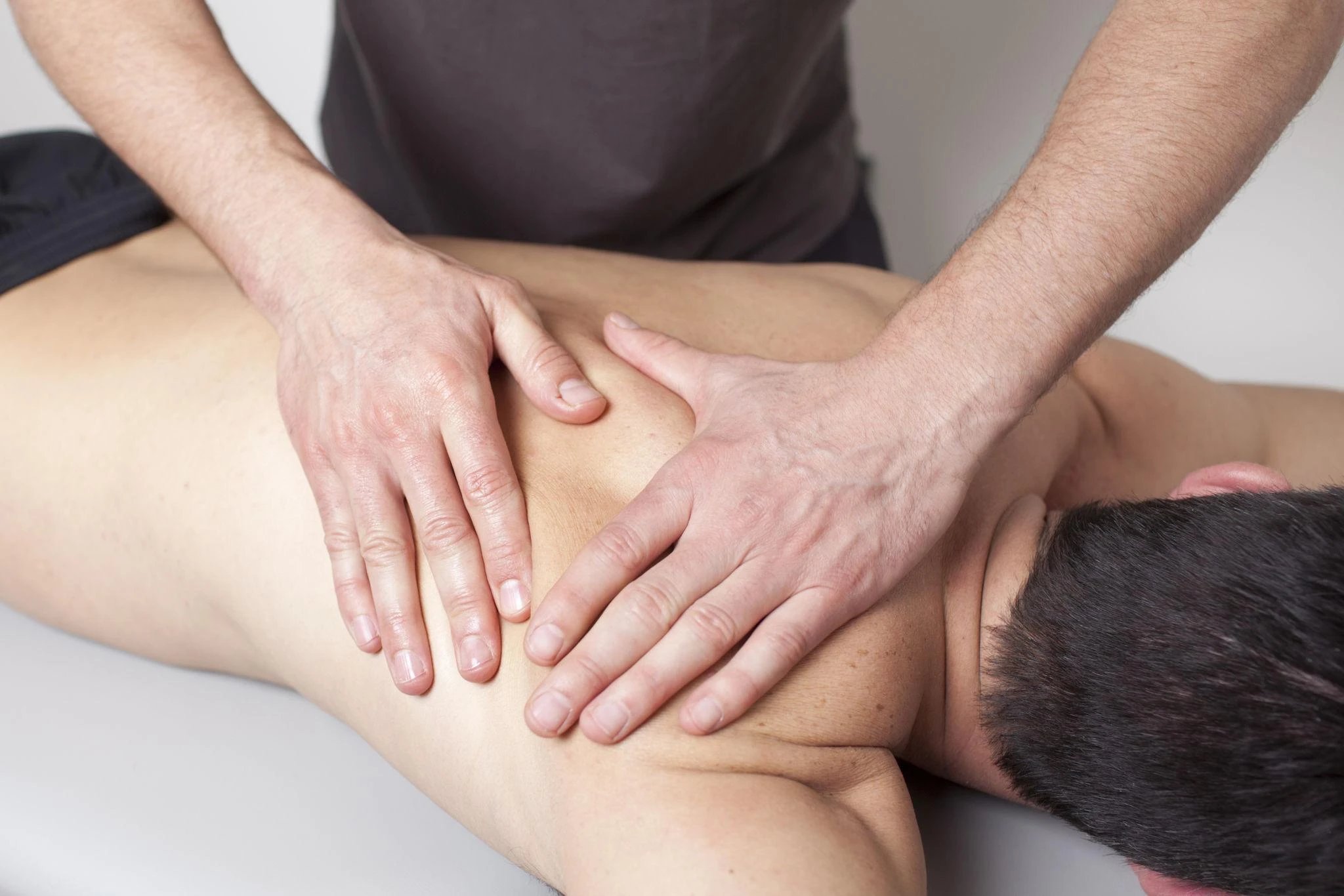 A massage therapist applying pressure to a client's back.