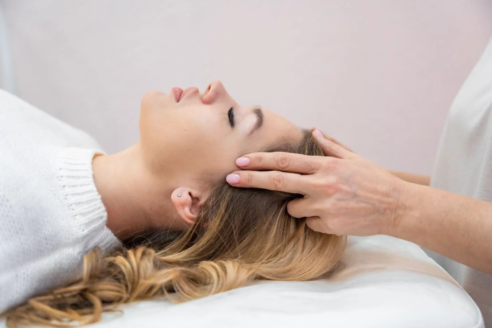 Woman receiving a scalp massage in a serene setting