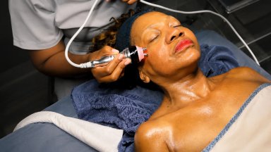 Woman receiving a facial treatment with a device