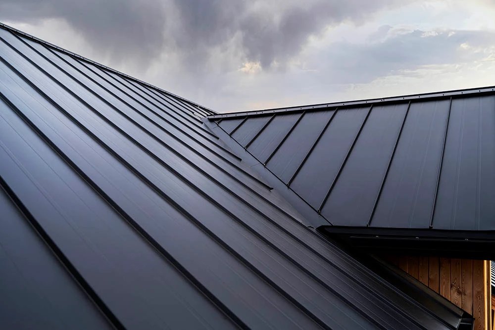 Metal roof with modern design against a cloudy sky