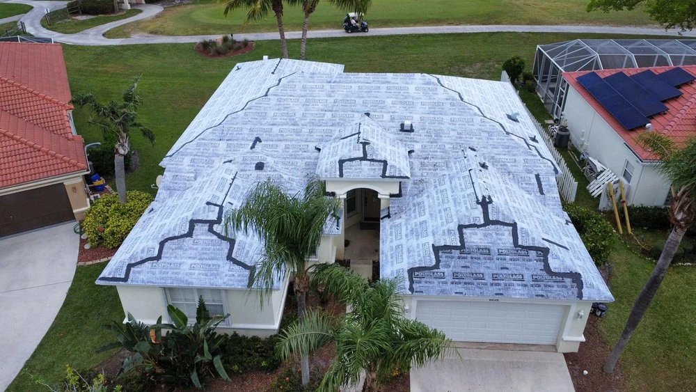 Aerial view of a house with a new roof being installed.
