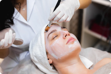 Woman receiving a facial treatment with applied cream
