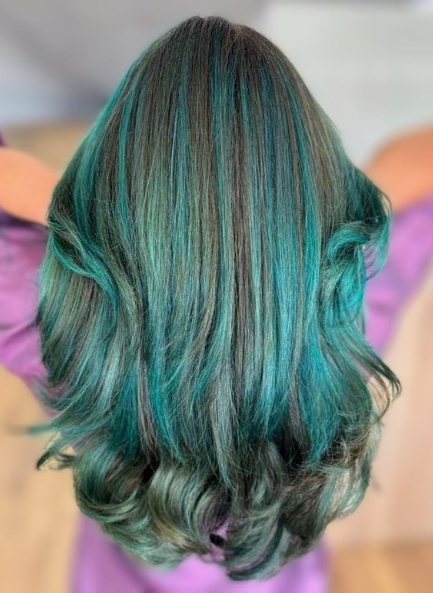 Vibrant teal and black hairstyle with waves