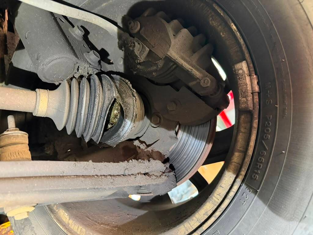 Close-up of a vehicle's axle and CV joint with visible grease