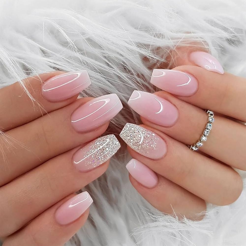 A close-up of elegantly manicured nails with a pink and glittery design.