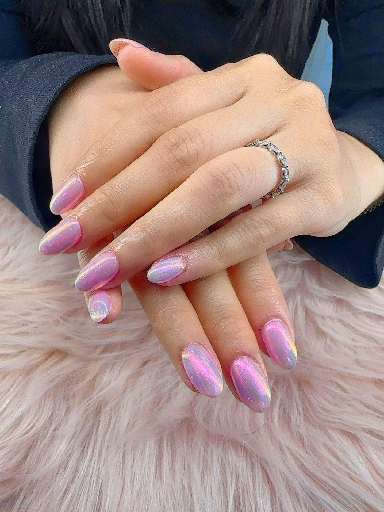 Hands with manicured nails on a plush surface
