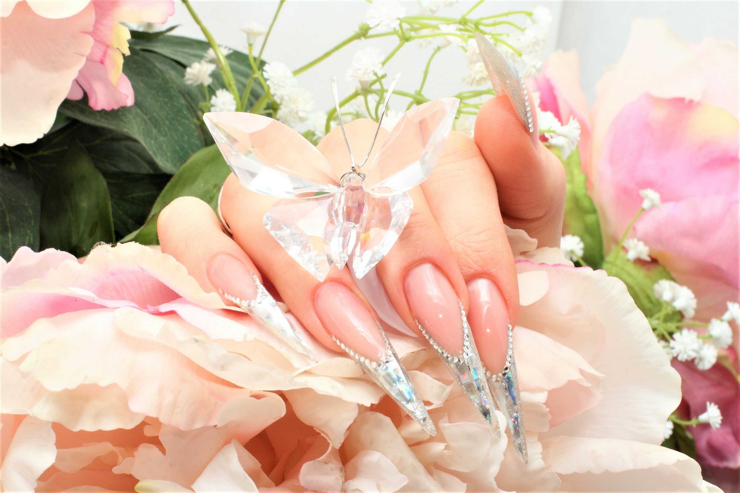 Elegant hand with crystal butterfly over floral background