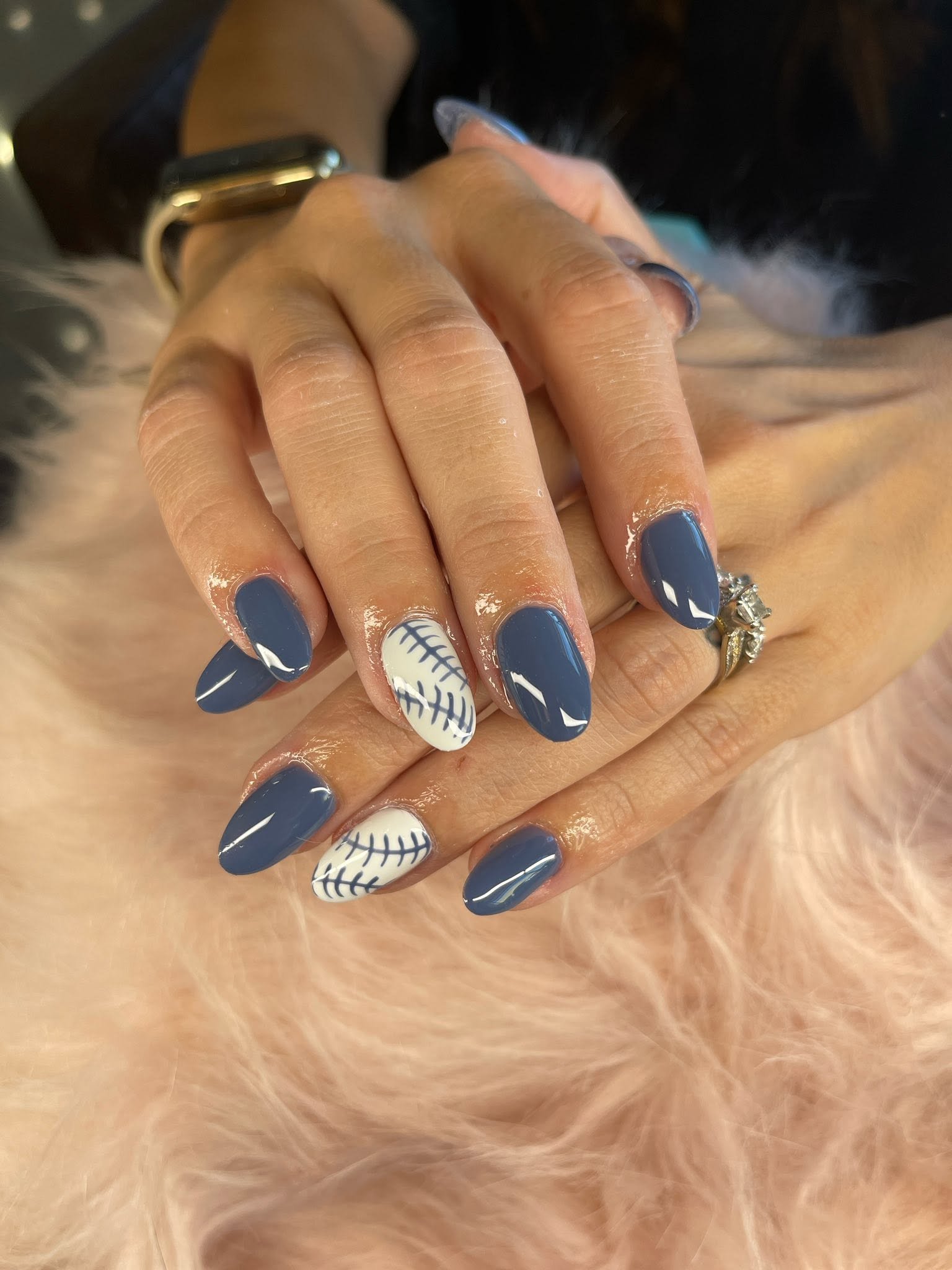 Nail design featuring dark blue and baseball-themed art