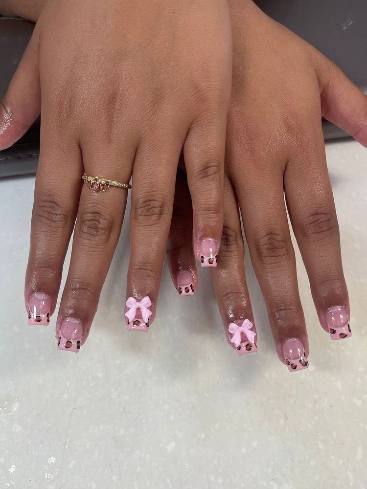 Beautifully manicured hands with pink nail art and bows.
