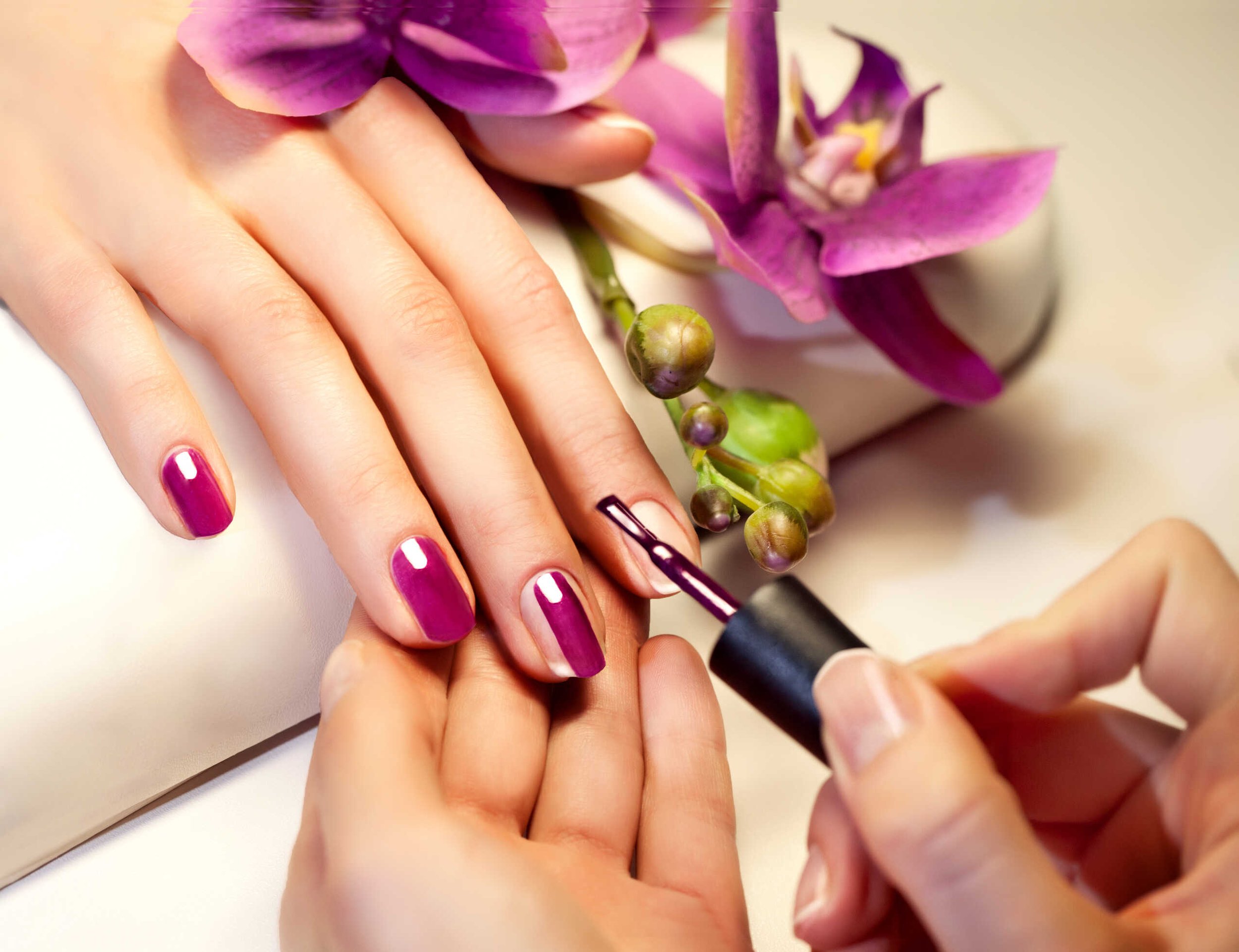 Person getting a manicure with purple nail polish