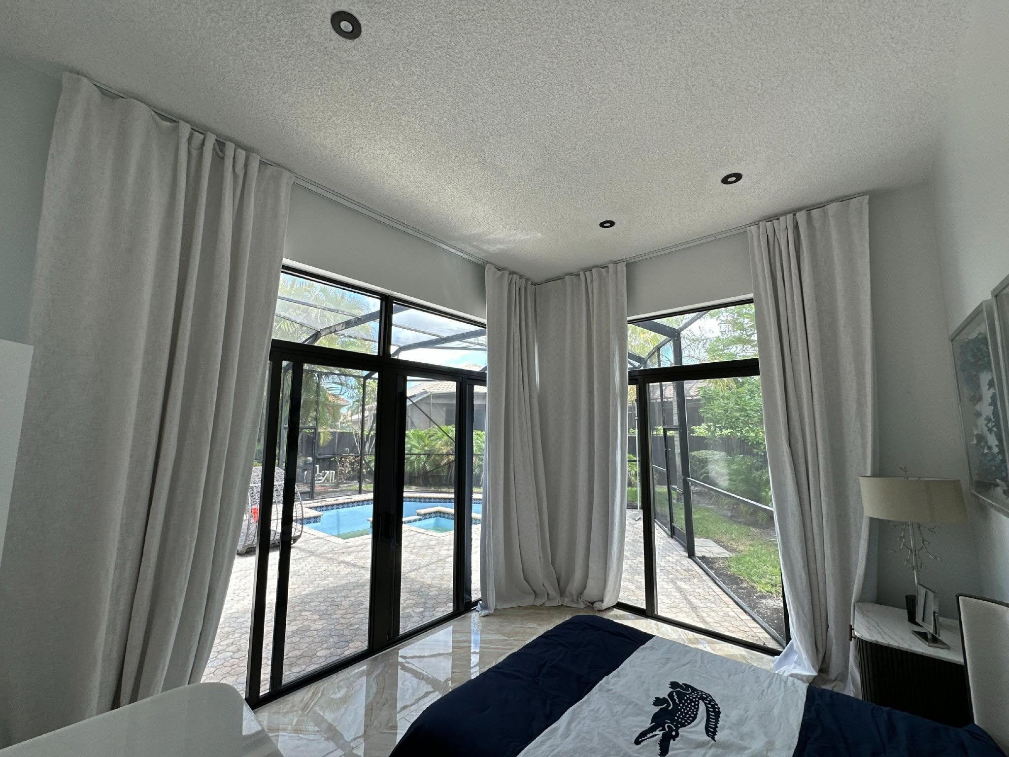 Modern bedroom with pool view through large windows