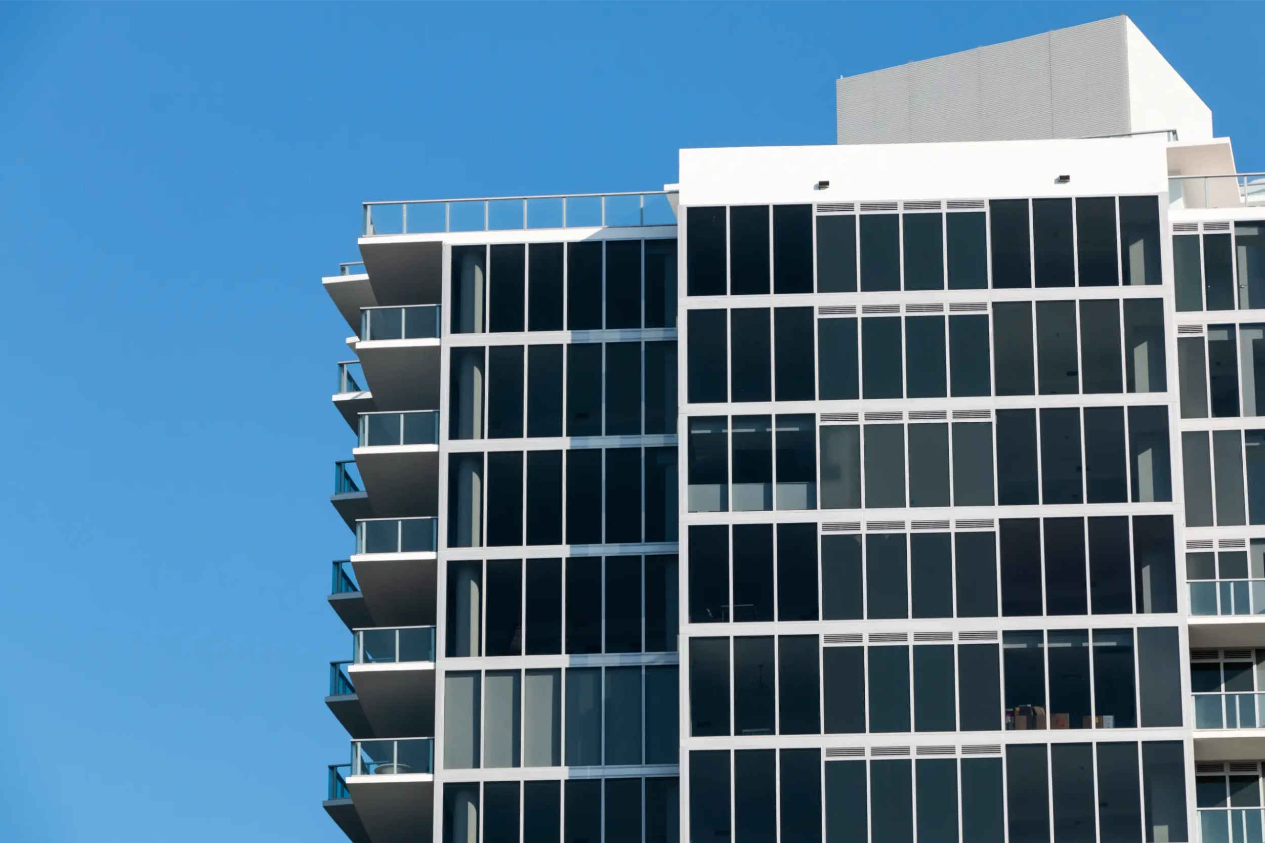 Modern glass facade of a building against blue sky