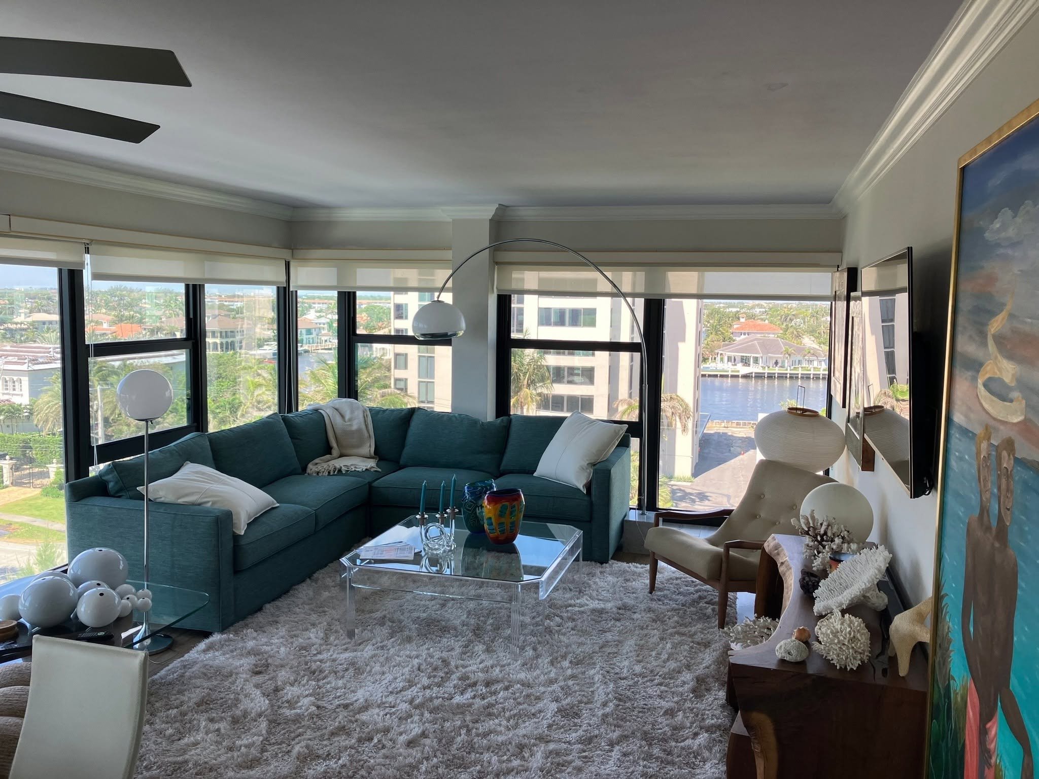 Modern living room with teal sectional sofa and glass table