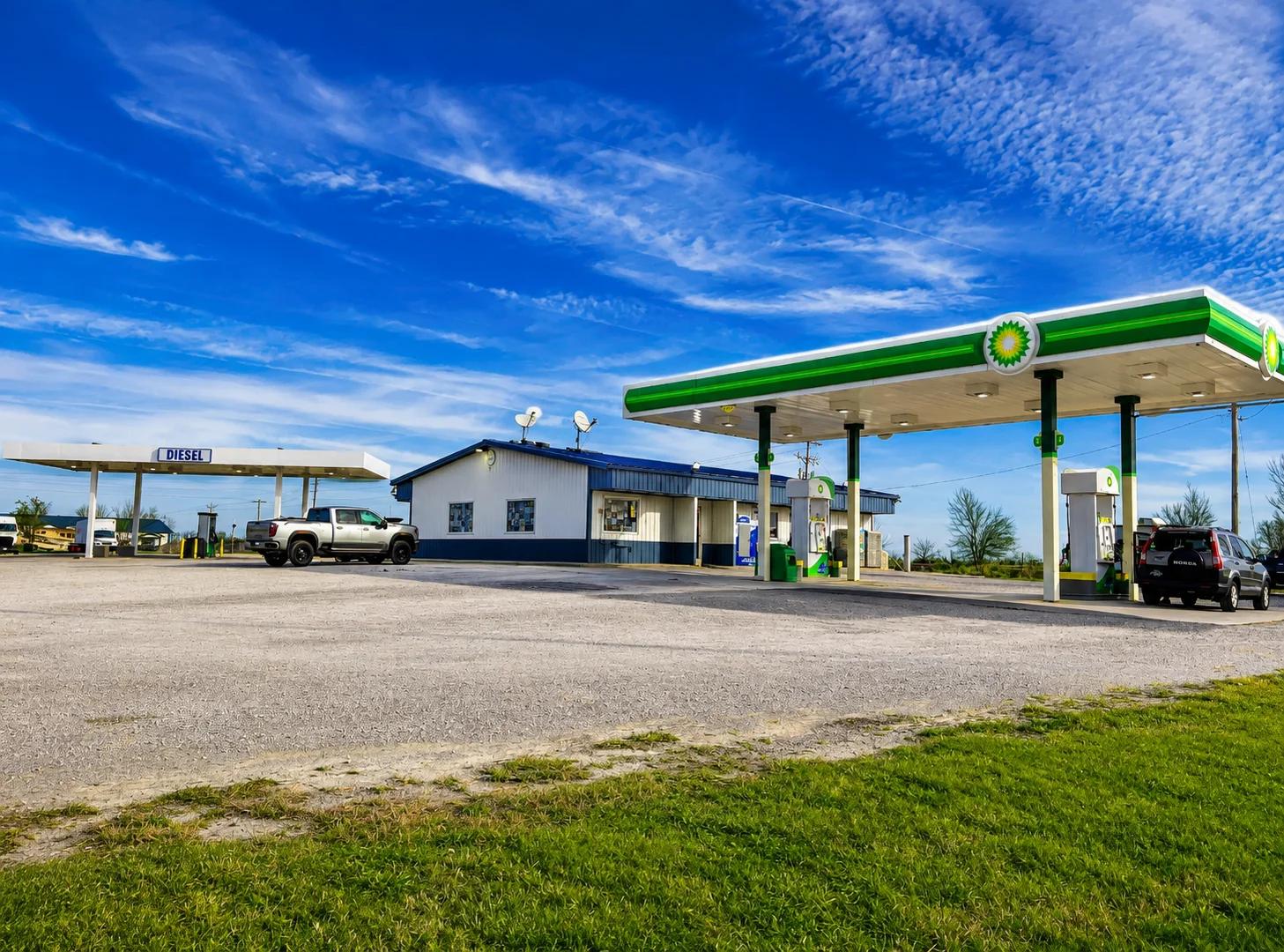 Gas station with two vehicles parked under a blue sky